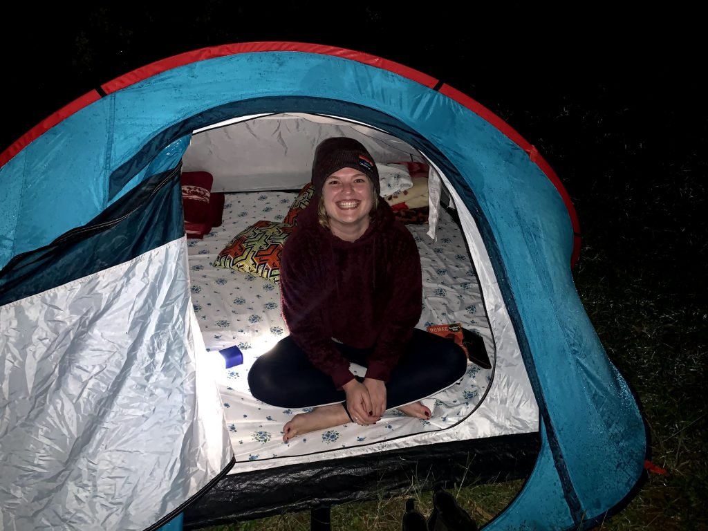 Biz Yoder inside a tent, outside is dark
