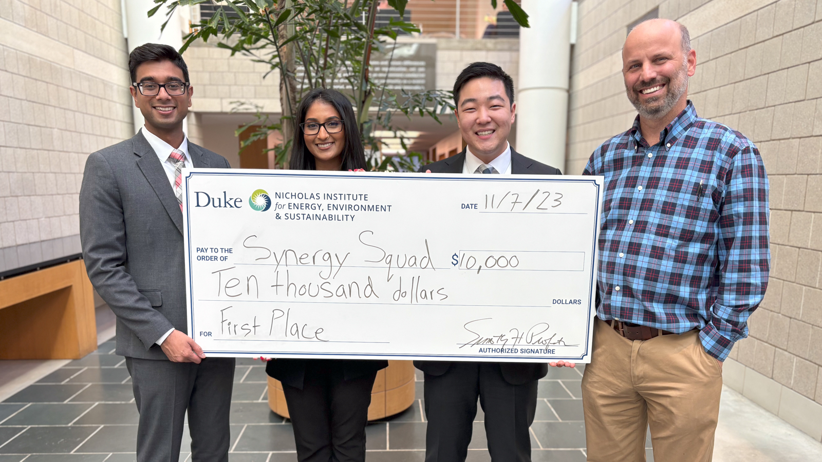 The winners of the 2023 Energy in Emerging Markets Case Competition holding a giant novelty check for $10,000."